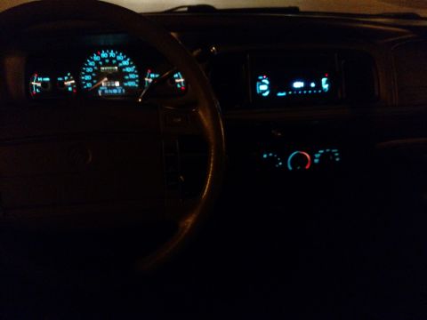 1995 Mercury Grand Marquis - The illuminated dashboard and radio display of a car are visible in the dark.