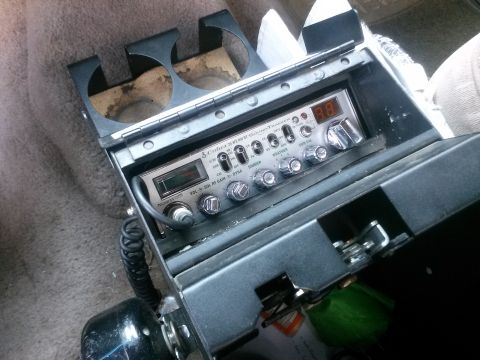 1996 Ford Bronco - A Cobra 25 LTD CB radio is visible inside a vehicle's interior, mounted in a console with cup holders.