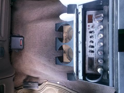 1996 Ford Bronco - CB radio installed in the center console of a vehicle, with cup holders visible.