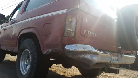 1981 Ford Bronco - This 1981 Ford Bronco shows significant rear-end collision damage, including a missing taillight and dented bumper.