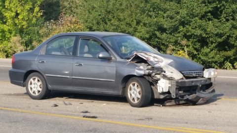 1981 Ford Bronco - A gray sedan sustained heavy front-end damage after a collision.