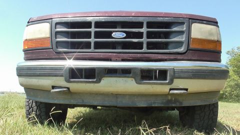 1996 Ford Bronco - Close-up of a Ford truck's front grille and bumper, showing the iconic Ford emblem.