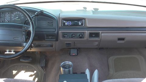 1996 Ford Bronco - The interior of a truck is shown, the dashboard, steering wheel, and center console.