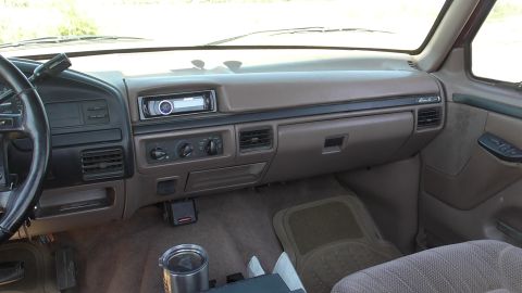 1996 Ford Bronco - Interior view of a brown dashboard with climate controls and an aftermarket stereo system.