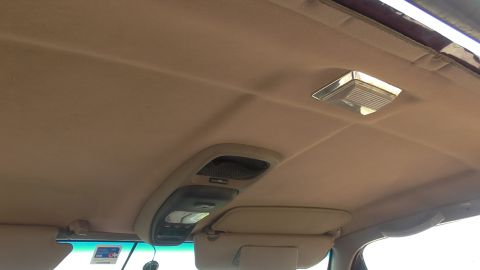 1996 Ford Bronco - Interior view of a vehicle's tan headliner, showing the overhead console and dome light.