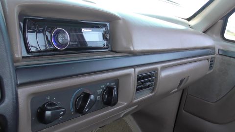 1996 Ford Bronco - The interior of a vehicle shows the dashboard with a Pioneer stereo and climate control knobs.