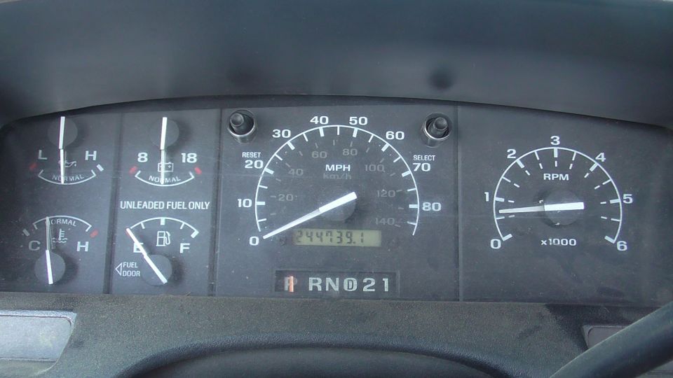 Vehicle dashboard with speedometer, tachometer, fuel gauge, and temperature gauge. Odometer reads 244739.1