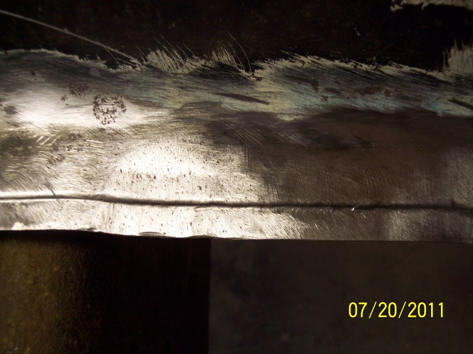 Close-up of a scratched metal panel with a horizontal seam. Date stamp '07/20/2011' and 'SUPERMOTORS' logo visible