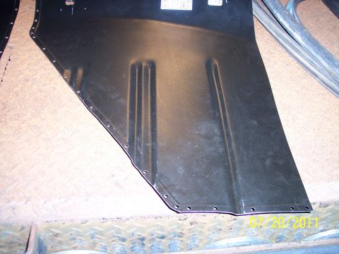 1973 Ford F-250 - A black metal panel with stamped ribs and bolt holes is shown, likely a vehicle part.