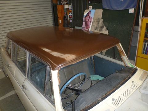 1962 MG B - The interior of a station wagon shows a blue steering wheel and seats, with a newly painted brown roof.