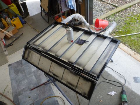 1962 MG B - Car hardtop being painted in a garage setting with various tools and supplies visible.