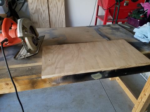 1994 Ford Bronco - A circular saw and plywood are on a workbench, with a sandblaster visible in the background.