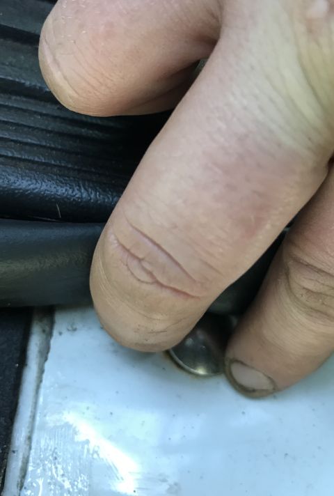 1995 Ford Bronco - A hand is shown near a metal fastener and black trim, with the Supermotors.net logo visible at the bottom.