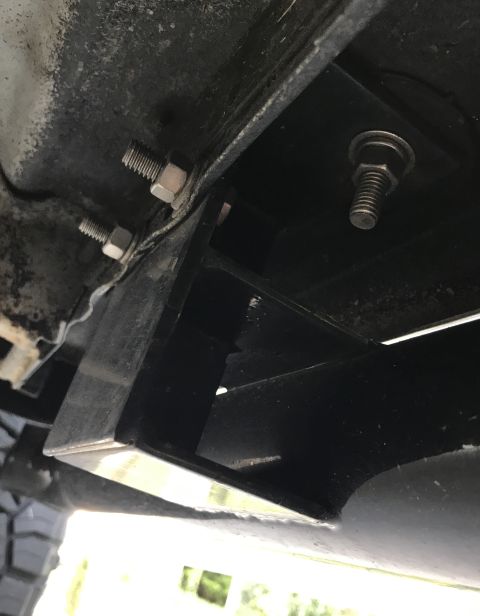 1995 Ford Bronco - Close-up view of the underside of a vehicle, showing mounting hardware and structural components.