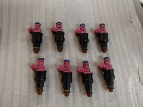 1995 Mercury Grand Marquis - Set of eight fuel injectors, likely for a V8 engine, displayed for sale.