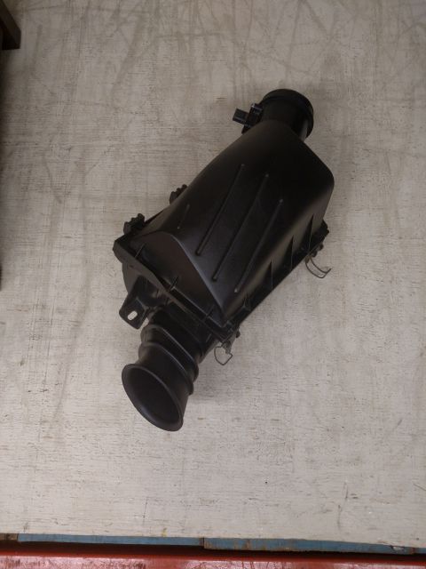 1995 Mercury Grand Marquis - This is a vehicle part, an air cleaner housing, shown against a textured background.