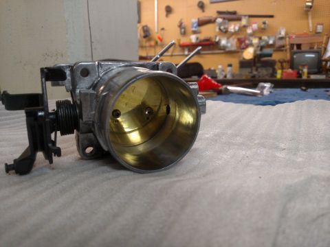 1995 Mercury Grand Marquis - A close-up of a throttle body sits on a cloth, with a workshop visible in the background.