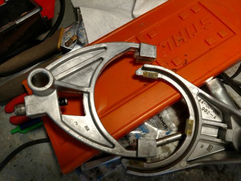 1992 Ford Bronco - Close-up of two metal transfer case components, possibly for a Ford Bronco, resting on an orange case.