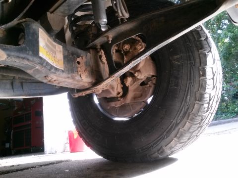 1996 Ford Bronco - Undercarriage view shows rusted suspension components and a tire.