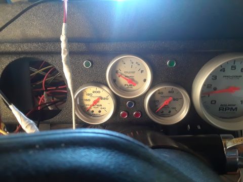 1985 Ford Bronco - A close-up view of aftermarket dashboard gauges, including fuel level, water temperature, and tachometer.