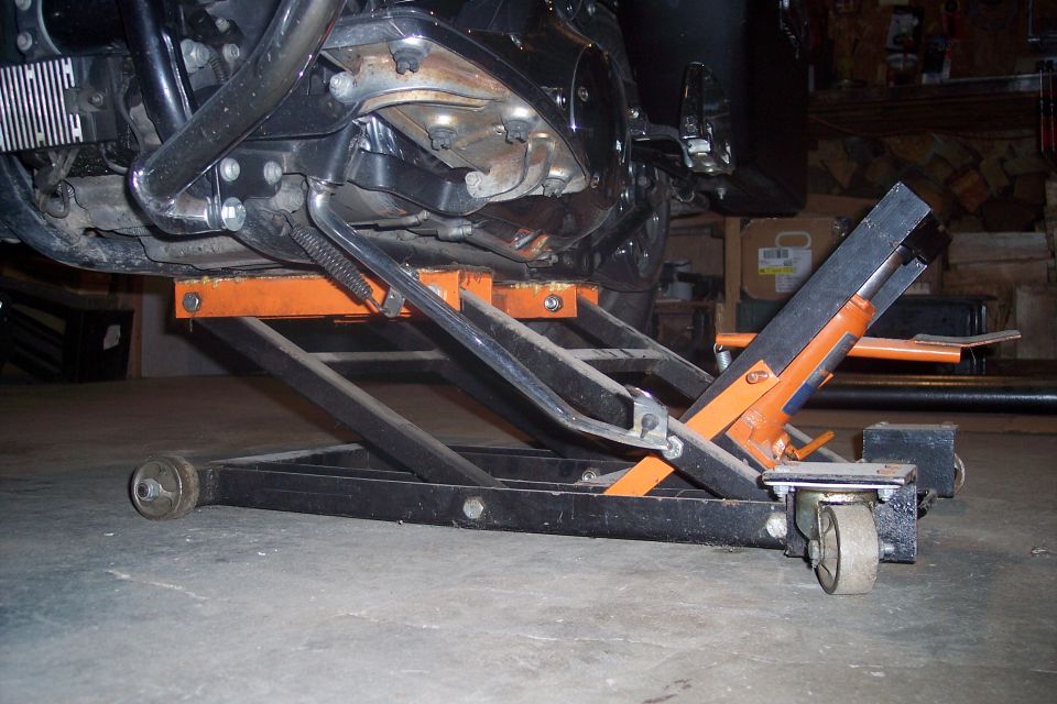 Motorcycle engine and frame supported by an orange scissor lift