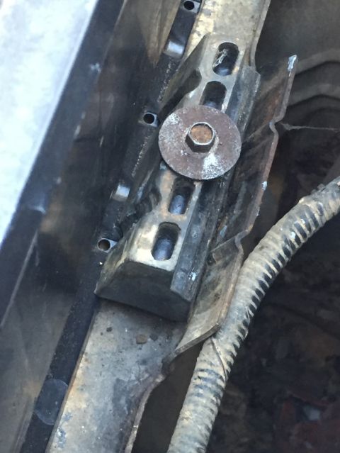 1988 Ford Bronco - Detail of a corroded mounting bracket on a vehicle's chassis, showing wear and tear.