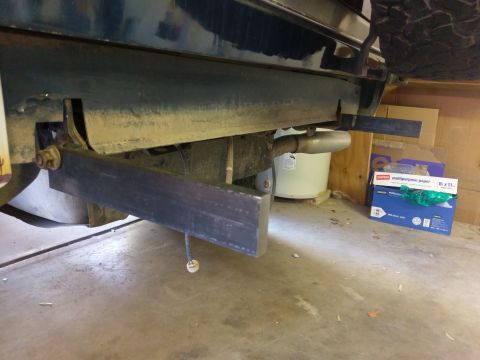 1988 Ford Bronco - Close-up view of the rear underside of a vehicle, showing the exhaust system and custom bumper modifications.