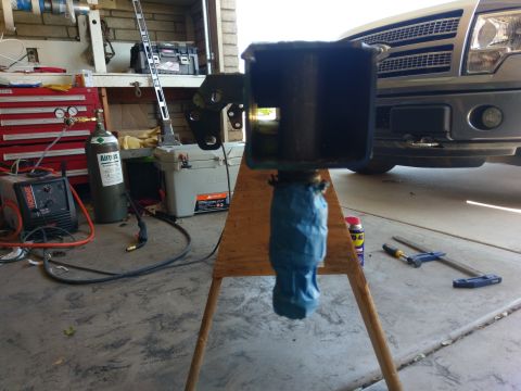 1988 Ford Bronco - A vehicle part is taped and mounted on a wooden stand, with a silver truck grille in the background.