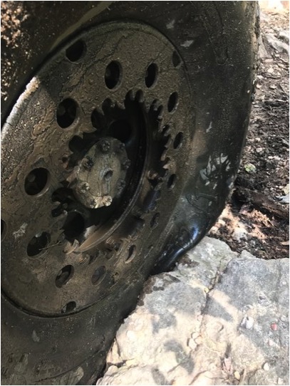 1989 Ford Bronco - The vehicle's tire is stuck on rocks, showing the intricate details of the wheel and gear system.