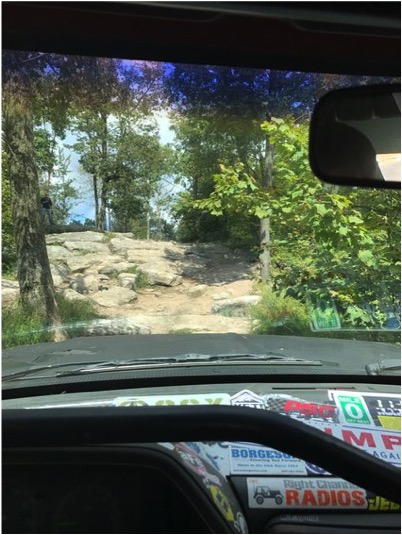 1989 Ford Bronco - View from inside a vehicle as it navigates a challenging rocky off-road path.