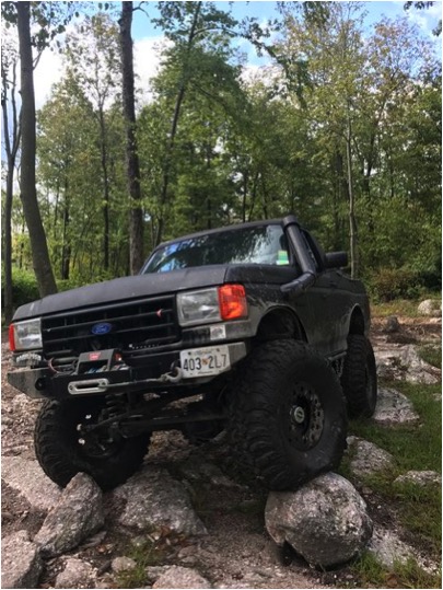 1989 Ford Bronco - This modified Ford truck is navigating a rocky trail.