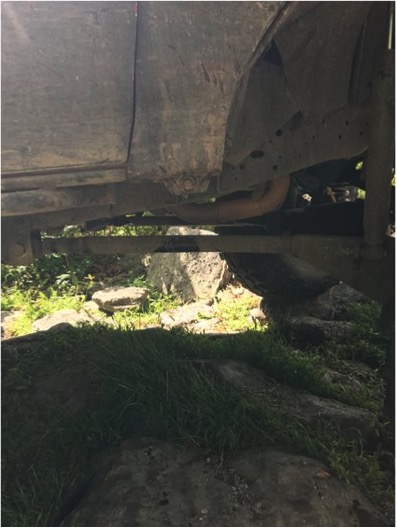 1989 Ford Bronco - The undercarriage of a 1989 Ford Bronco is visible, navigating rocky terrain.