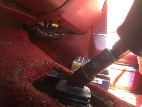 1986 Ford Bronco - The interior of a vehicle shows a manual transmission shifter and a box for a new water pump, suggesting a repair or modification.