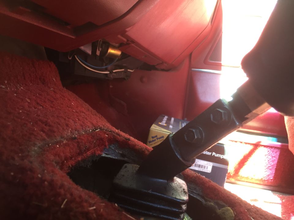 Interior view of a vehicle's manual shifter and a box for a new water pump