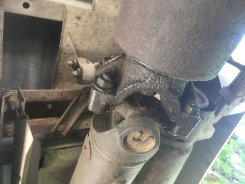 1986 Ford Bronco - Underside view of a vehicle's driveshaft universal joint, showing grease and wear.