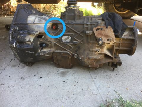 1986 Ford Bronco - A transmission housing is shown, with a blue circle highlighting a small red indicator light.