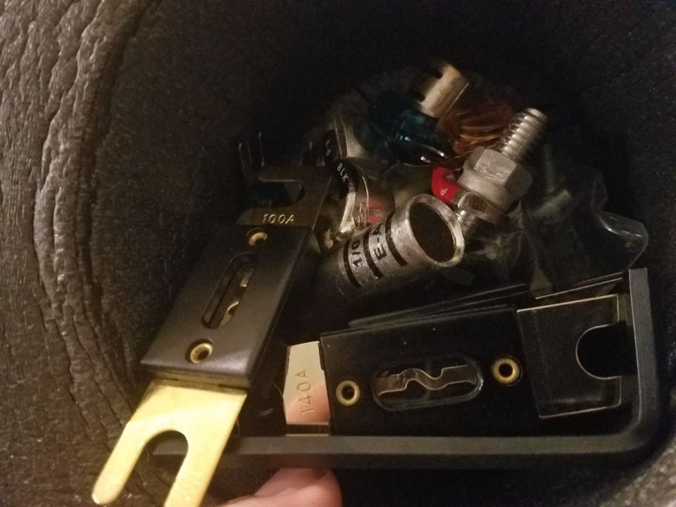 Close-up of automotive electrical parts including fuses labeled 100A and 140A