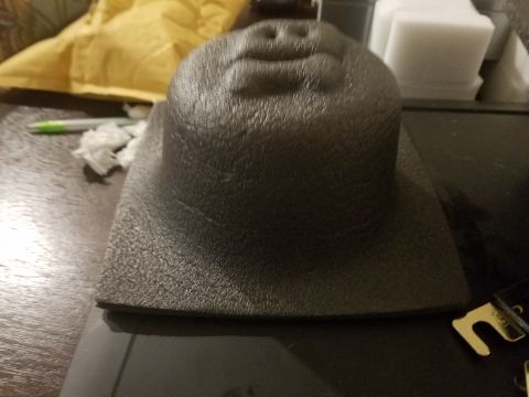 1994 Ford Bronco - A textured plastic cover, likely for a dashboard speaker, sits on a table.