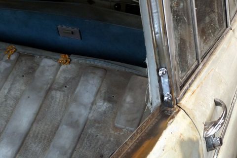 1962 MG B - Close-up of the interior of a vintage vehicle, showing the door frame, window, and seating area.