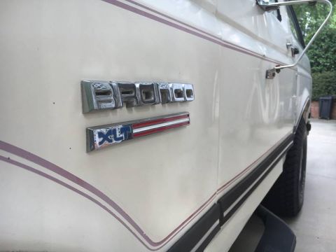 1988 Ford Bronco - Close-up of the side panel showing the 'Bronco' and 'XLT' badging on the vehicle.