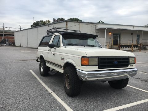 1988 Ford Bronco - This white 1988 Ford Bronco is seen from a three-quarter front view, equipped with a roof rack.