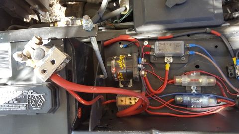 1978 Ford Bronco - Close-up view of a vehicle's battery and electrical wiring system, including fuses and a Stinger component.