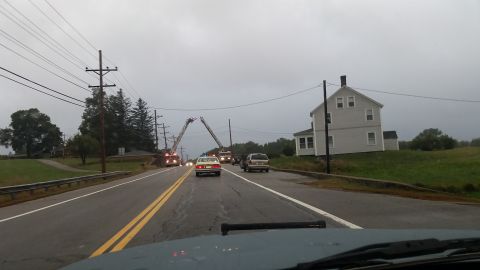 1991 Ford Crown Victoria - Emergency vehicles are present on a rural road next to a house on an overcast day.