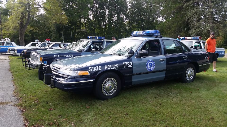 Several state police cars parked on grass, one in foreground has 'STATE POLICE 1732' on the side