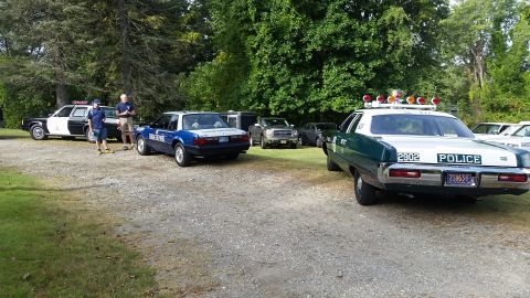 1991 Ford LTD Crown Victoria - A vintage police car is seen from the rear, displaying 'POLICE' and the number '2902' on its trunk.