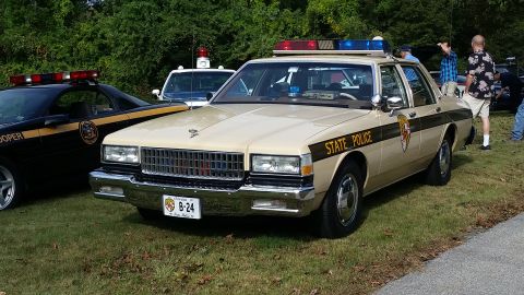 1991 Ford LTD Crown Victoria - A vintage state police car is displayed at an outdoor event, with another trooper vehicle nearby.
