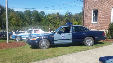 1991 Ford LTD Crown Victoria - Side view of a 1991 Ford Crown Victoria marked as State Police car 1732, with other police vehicles in the background.