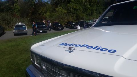 1991 Ford LTD Crown Victoria - A white police car with "MetroPolice" text on the hood is parked near other vehicles.
