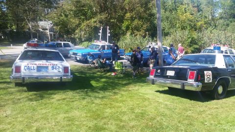 1991 Ford LTD Crown Victoria - Several police cars, including a 1991 Ford Crown Victoria, are parked on a grassy area.