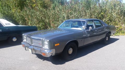 1991 Ford LTD Crown Victoria - This 1977 Dodge Monaco is parked next to a police vehicle under a sunny sky.